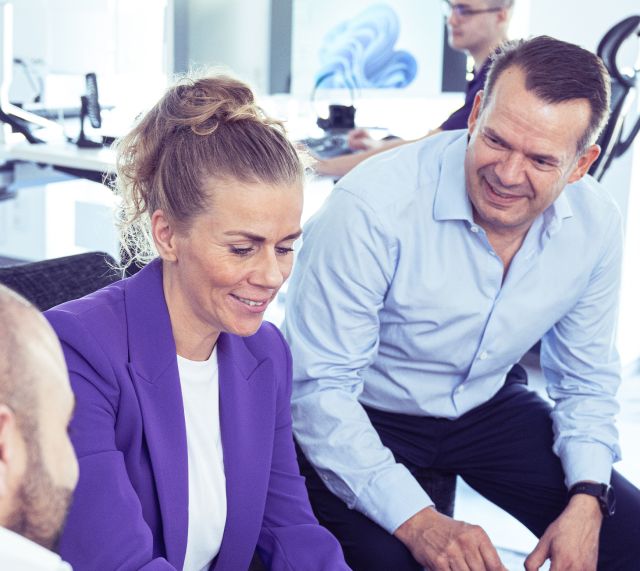 Drei Menschen besprechen etwas am Tablet